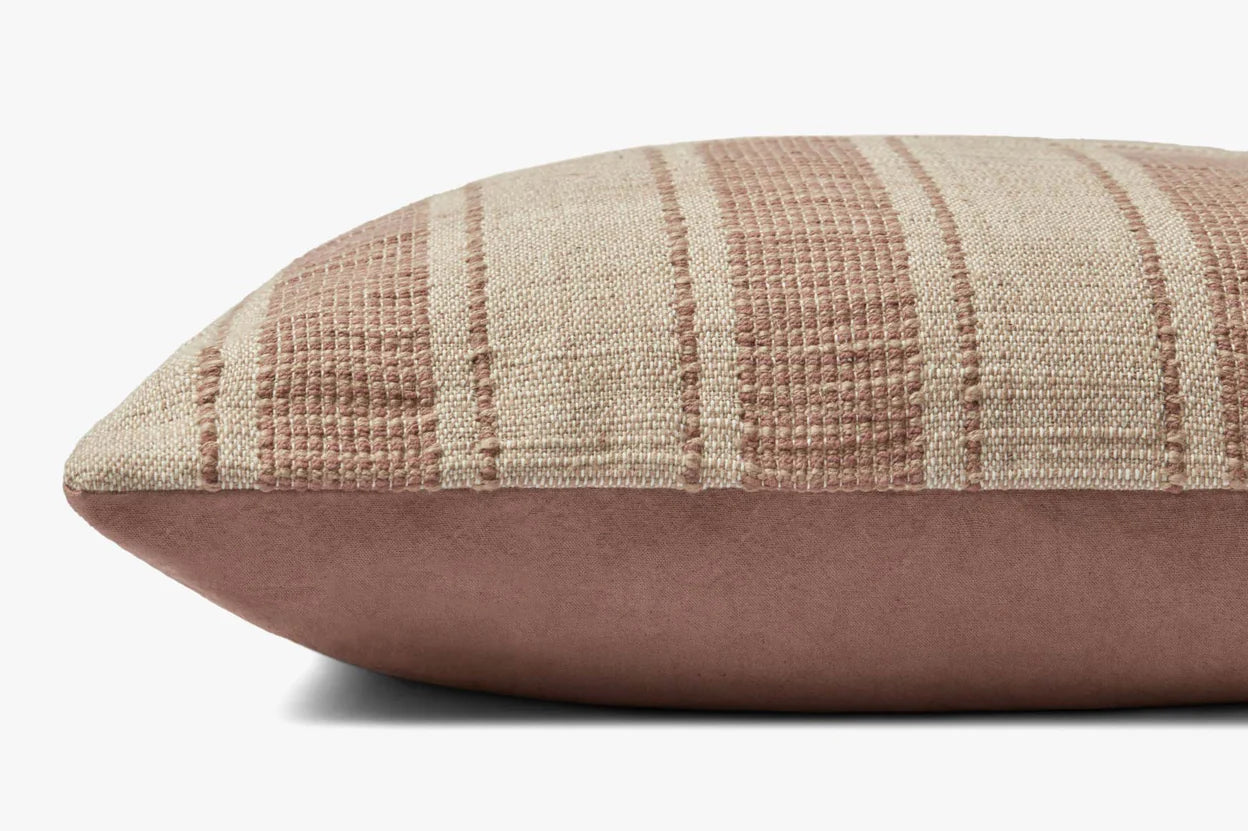 A close-up side view of the Marin Natural 22x22 pillow by Loloi Rugs, crafted from hand woven cotton with beige and muted pink stripes on top, solid muted pink sides and bottom, and an antique bronze zipper.