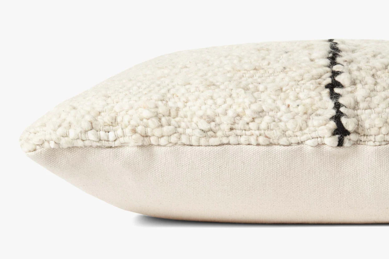 The Carla Ivory Pillow 22x22 by Loloi Rugs is a handwoven, rectangular cream wool pillow with a black stitched line on top and a hidden flap zipper, shown close-up on a plain white background.