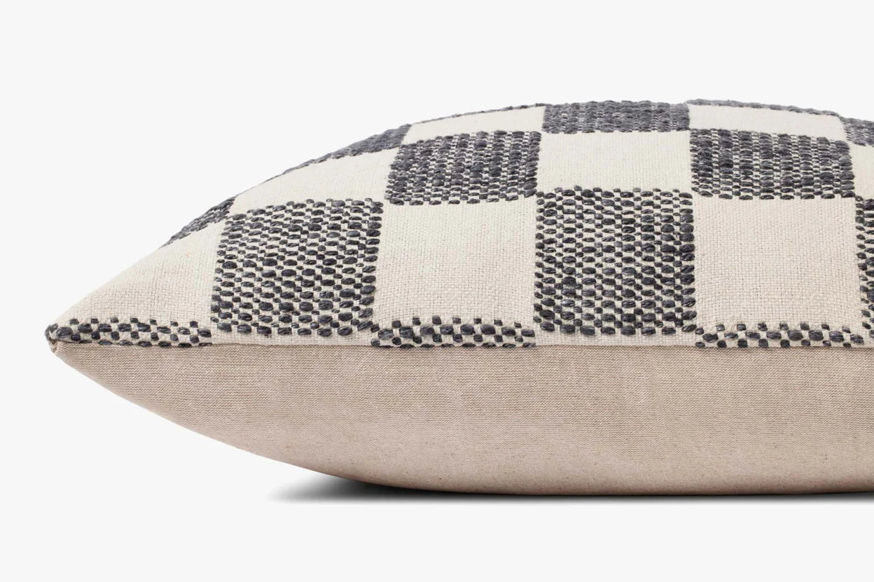 The PLL0123 pillow 22x22 by Loloi Rugs features a textured black and white checkerboard top with plain beige sides, adding modern style to any living room. Displayed on a white background.