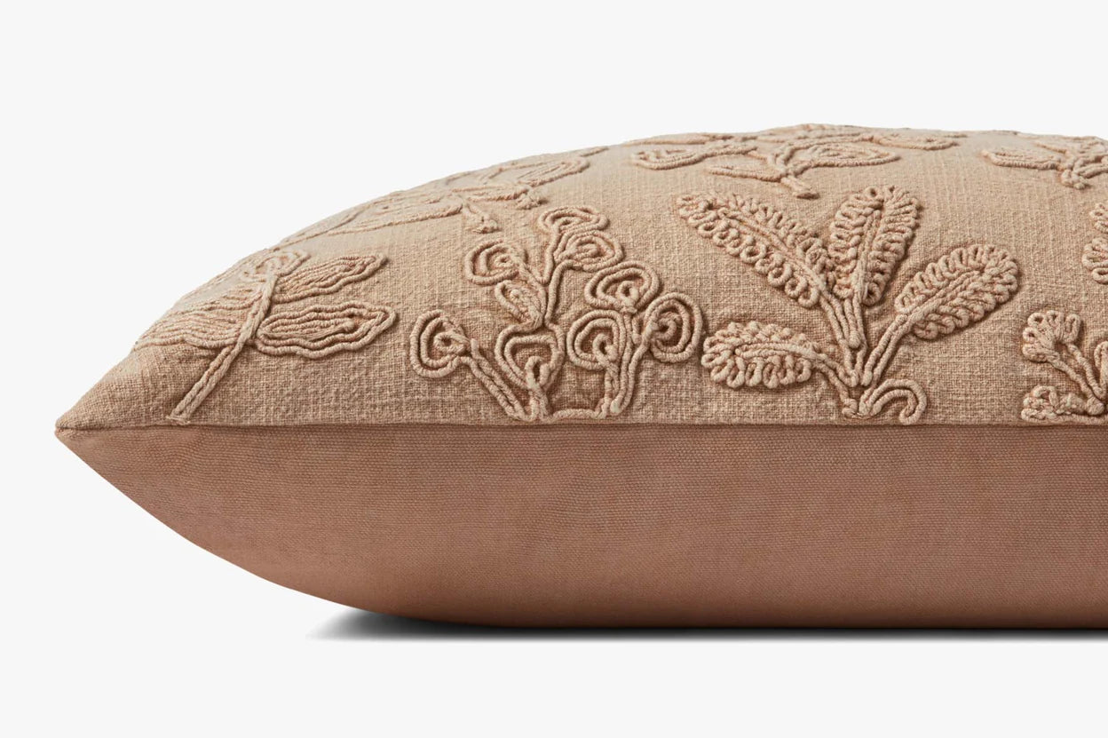 The PMH0054 Louise Natural Pillow 12x27 by Loloi Rugs is a rectangular beige linen pillow featuring textured, embroidered botanical patterns, displayed from the side against a white background.