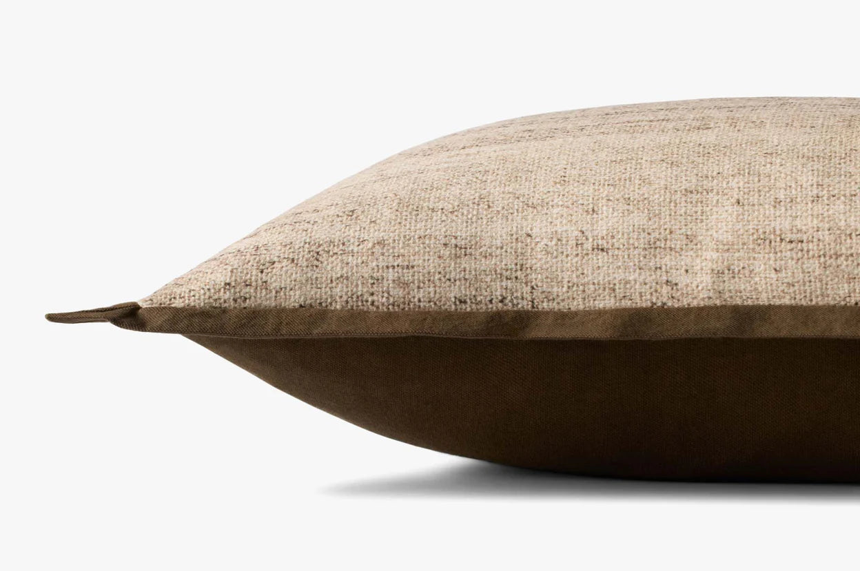 A close-up side view of the PLL0143 Brown Pillow by Loloi Rugs, featuring textured beige cotton fabric on top and smooth dark brown polyester on the bottom, set against a plain white background.