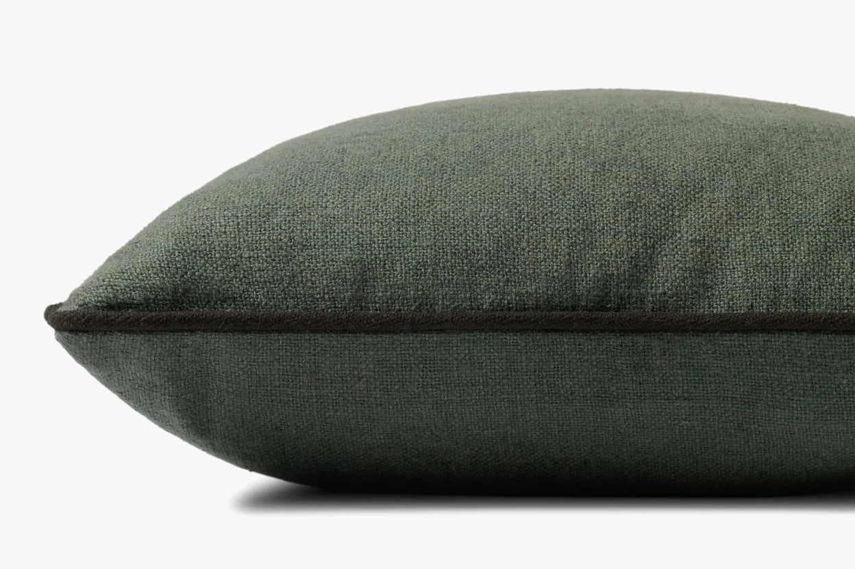 A close-up side view of the Hudson Blue Pillow 20x20 by Loloi Rugs shows its textured surface, dark edge piping, and hidden zipper, set against a plain white background.