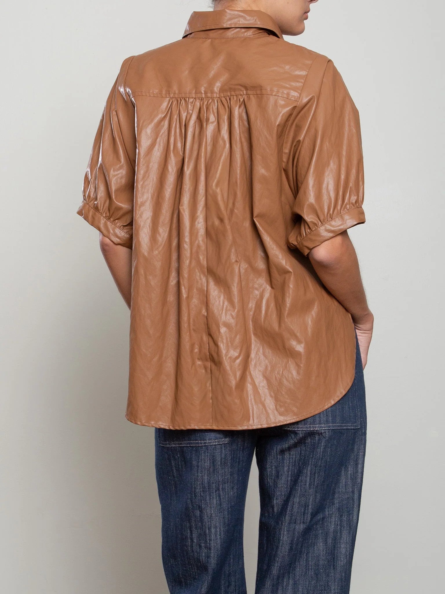 Shiny brown Pharaoh Claude Shirt with voluminous sleeves, styled with dark jeans, Bungalow Furniture &amp; Accessories.