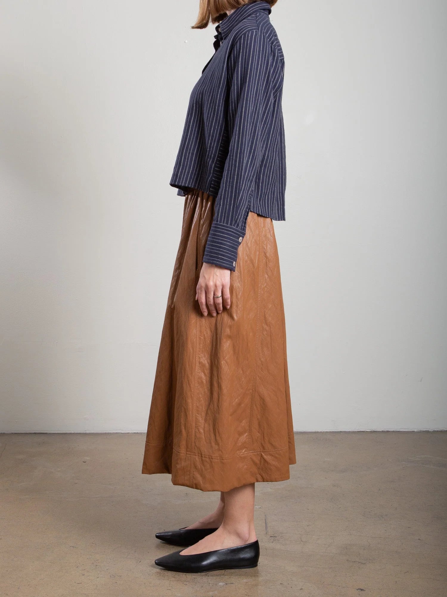Brown Pharaohs Claudia Skirt with faux leather pockets, styled with a navy blouse and black flats.