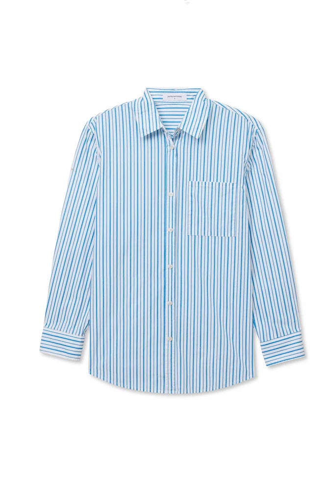 The Avalon Poplin Button Down by Perfectwhitetee is an oversized, long-sleeve cotton shirt with blue and white stripes, a left chest pocket, and a collar—an essential summer piece made from breathable poplin.