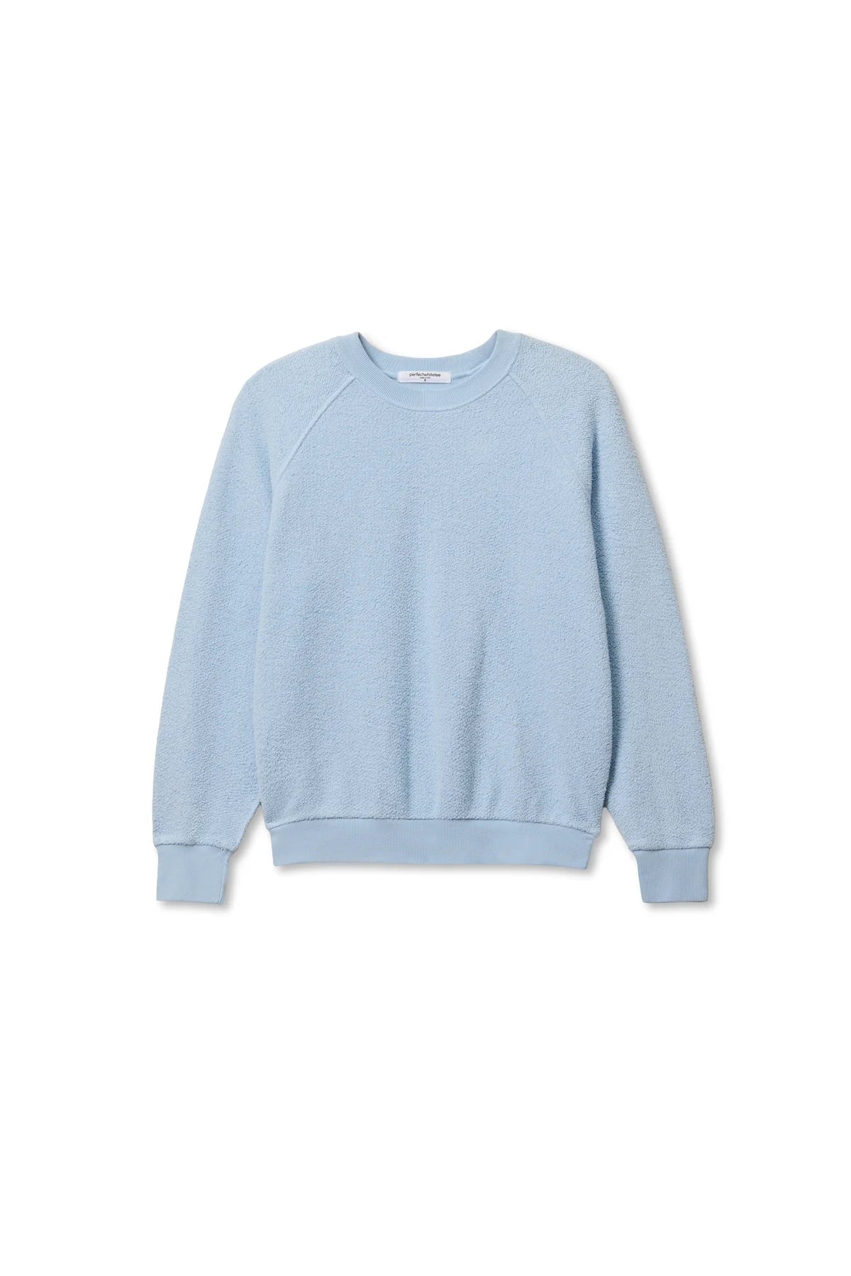 The Perfectwhitetee Ziggy Reverse LS Sweatshirt features a light blue shrunken fit with long sleeves, ribbed cuffs, collar, and hem, shown against a white background.