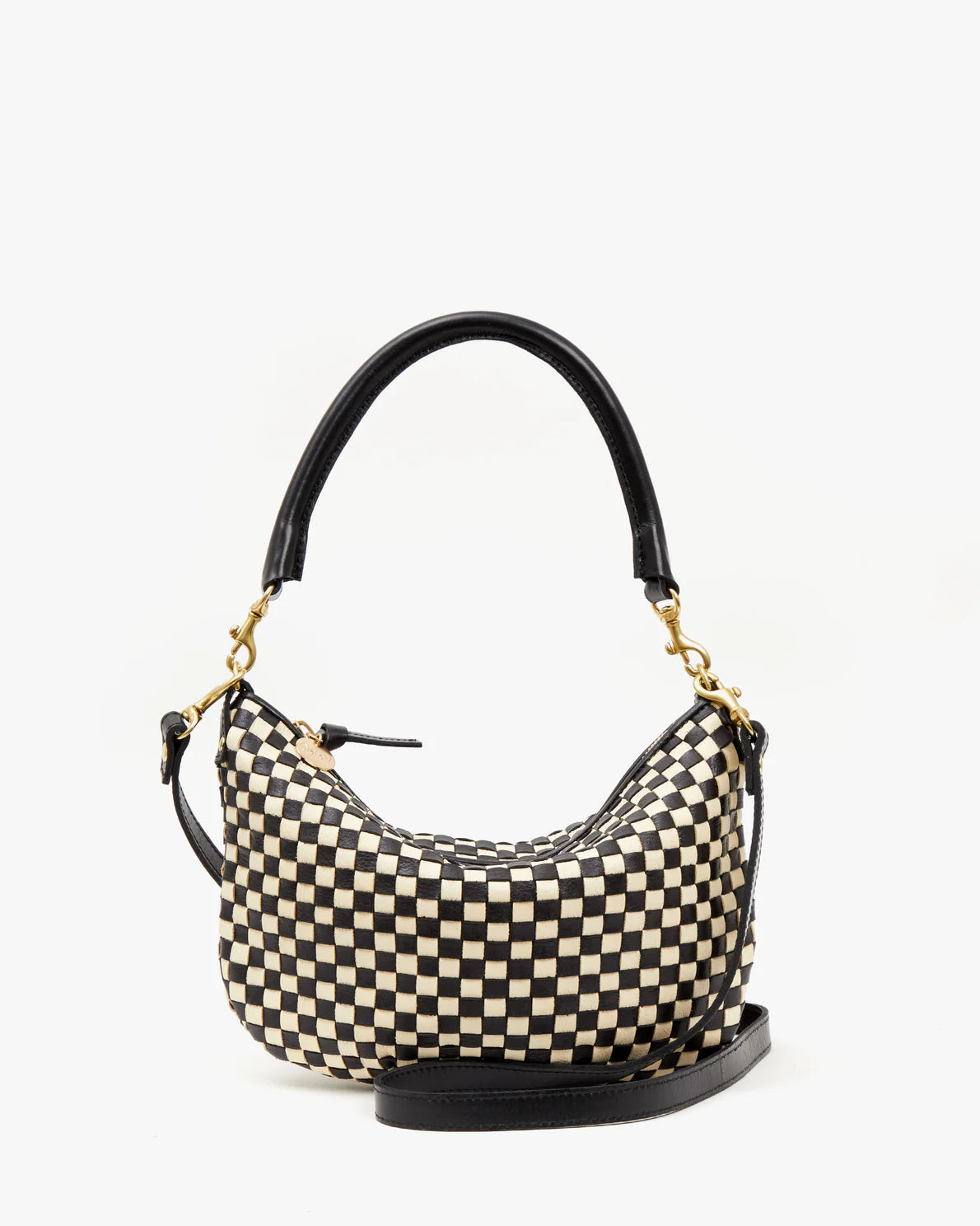 Introducing the Clare Vivier Petit Moyen Woven Checker, a small handbag with a distinctive black and beige-checkered pattern. This elegantly curved bag features a black leather top handle secured with gold hardware clasps, adding a touch of sophistication. The handwoven leather bottom enhances durability without compromising on style.