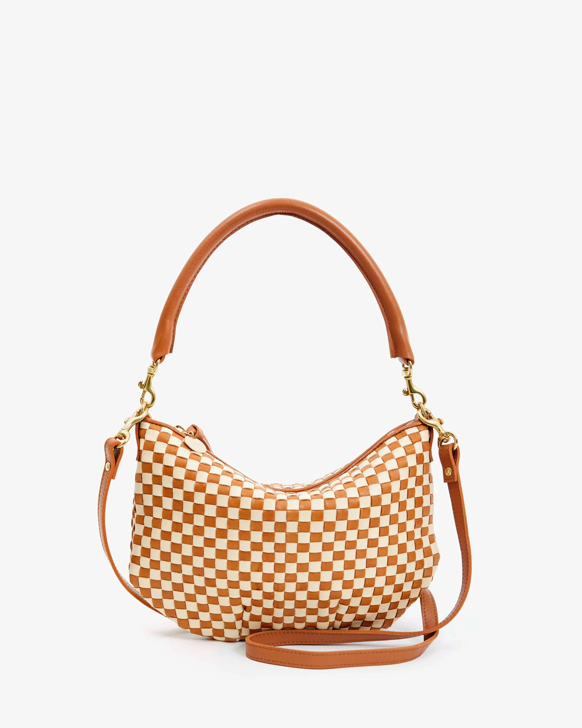 The Clare Vivier Petit Moyen Woven Checker is a stylish brown and white checkerboard handbag, featuring a curved top handle and detachable crossbody strap in rich handwoven leather, with gold-toned hardware. It effortlessly combines elegance with versatility against a white background.