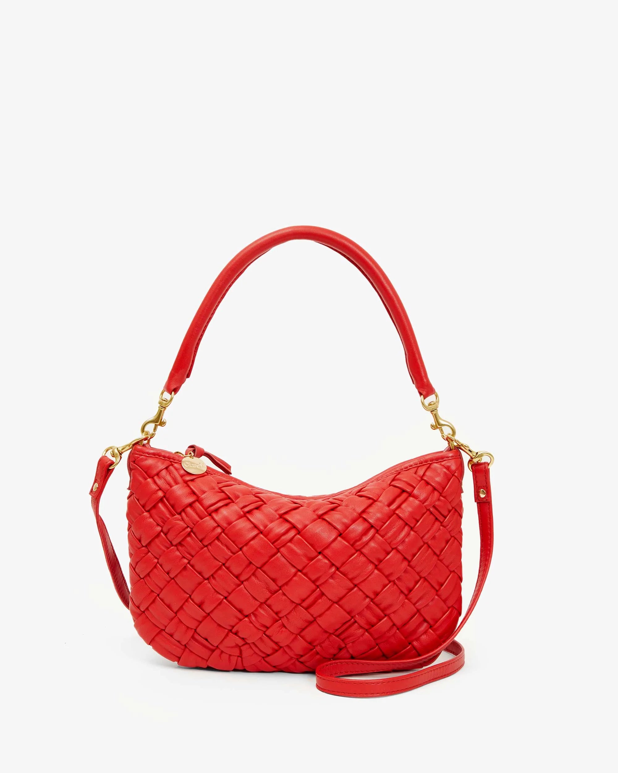 The Clare Vivier Petite Moyen is a red handwoven leather handbag featuring gold zippers and hardware. It has a single strap, adjustable crossbody straps, and boasts a smooth, rounded shape against a plain white background.