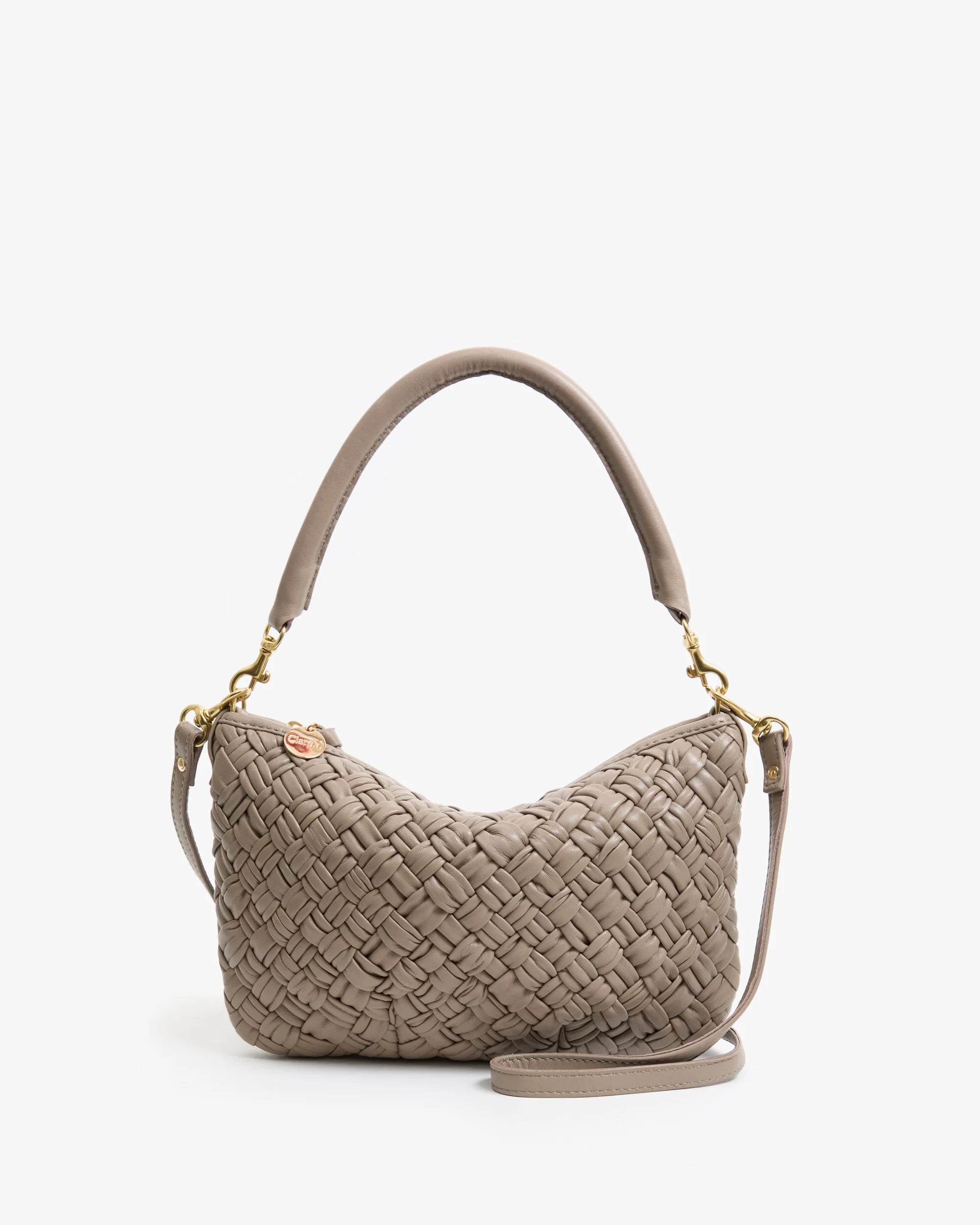 The Clare Vivier Petite Moyen S25 is a taupe handwoven leather mini messenger bag with a short handle, detachable crossbody straps, gold hardware, and a small charm by the zipper, shown against a plain white background.