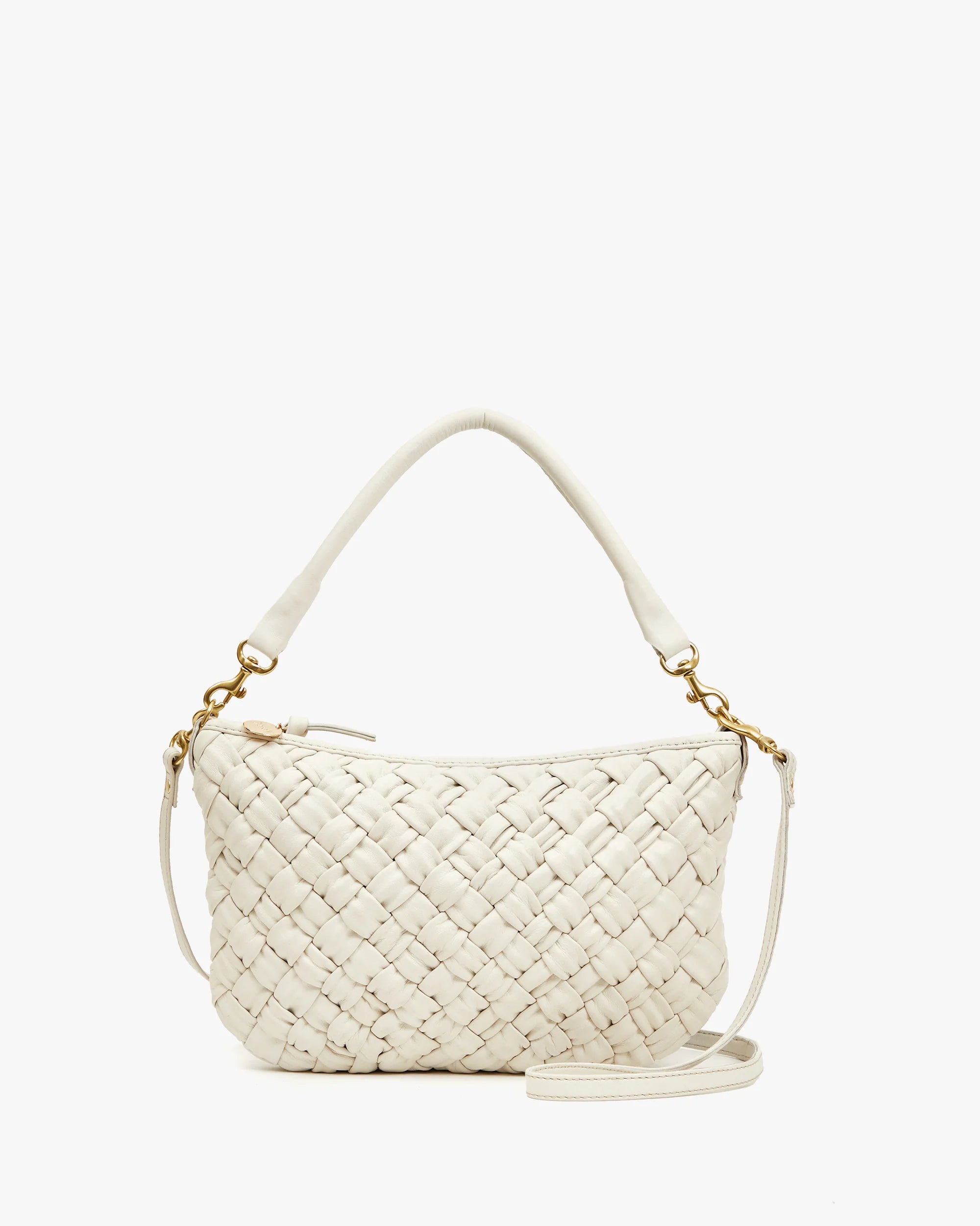 The "Petite Moyen" by Clare Vivier is a small white woven handbag with a handle and detachable crossbody strap, featuring gold hardware. Its intricate interlaced handwoven leather gives it a stylish and elegant look, set against a plain white background.