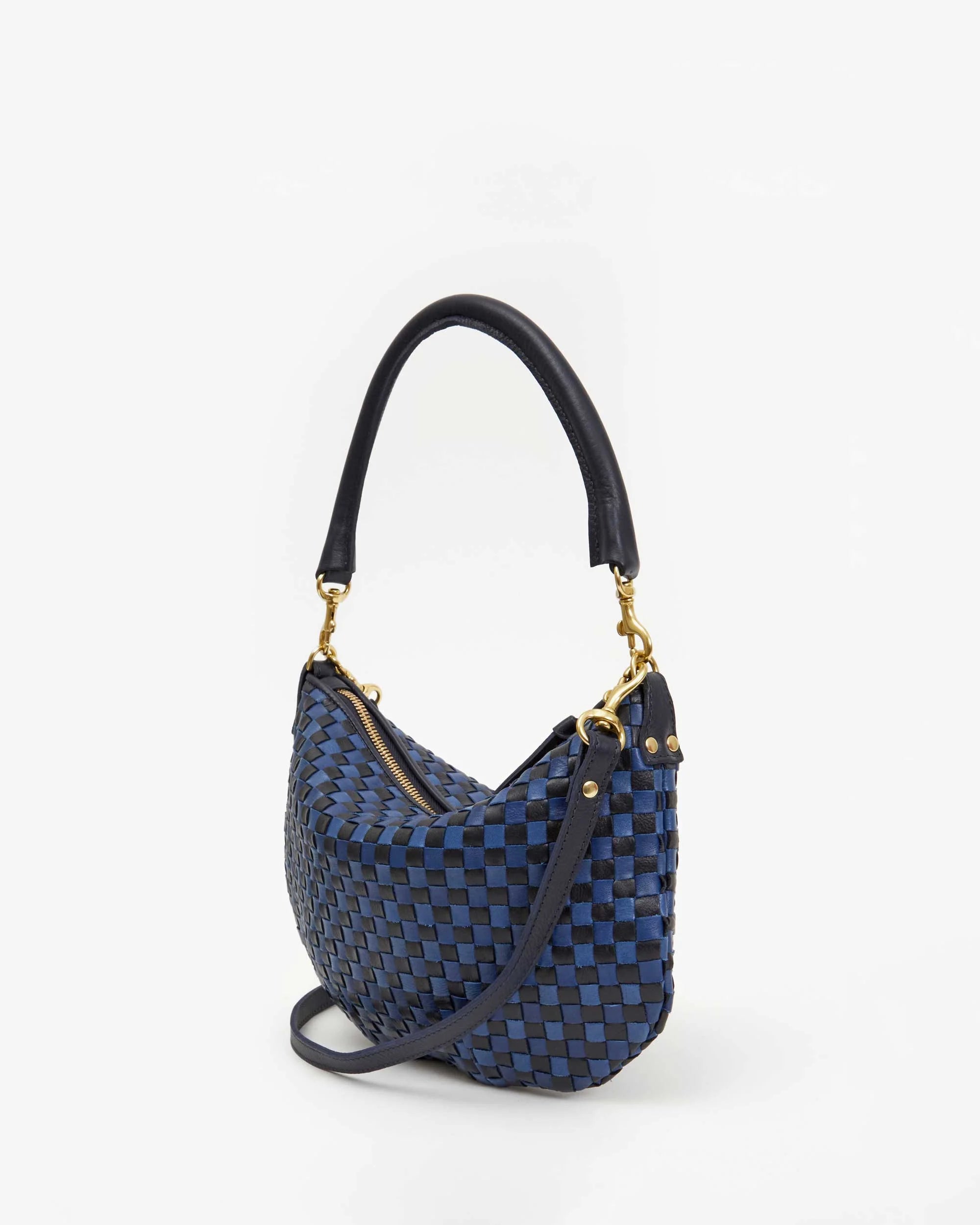 Introducing the Petite Moyen S24 by Clare Vivier: a chic mini messenger handbag with a woven black and blue checkered pattern, accented by elegant gold-tone hardware. It boasts a short handle, detachable crossbody straps, and is beautifully displayed against a plain white background.