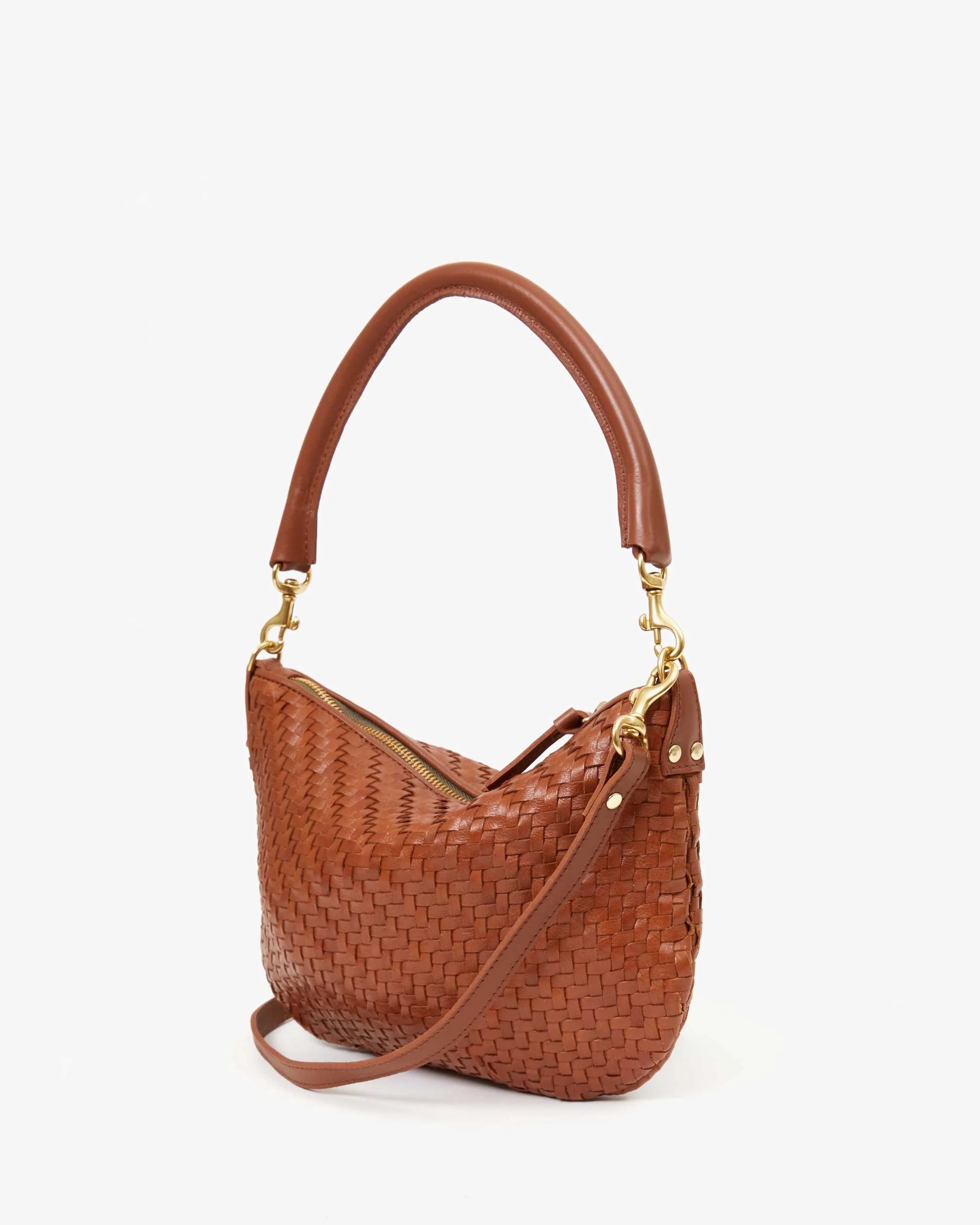 The Clare Vivier Petite Moyen is a handwoven leather handbag with a short, thick handle and crossbody straps. This mini messenger bag features gold-tone hardware and a top zipper closure, showcased against a plain white background.