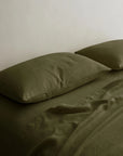 Linen pillowcases and sheet set by Cultiver Goods on a tidy bed in a minimalist bedroom setting.