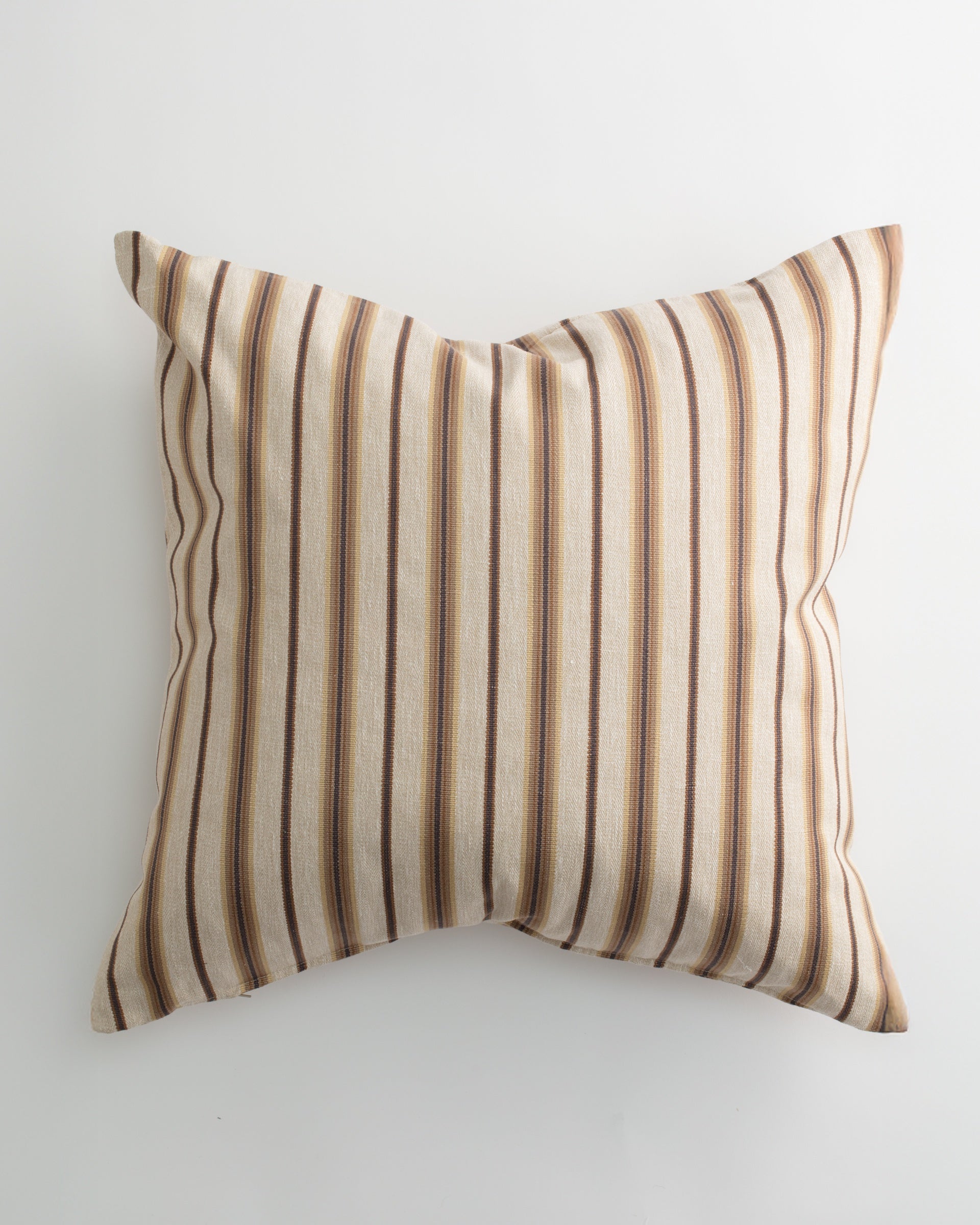 The ULSTER 26x26 Pillow by Pindler features brown, beige, and cream vertical stripes on a light background with a plush down feather insert, shown resting on a white surface.