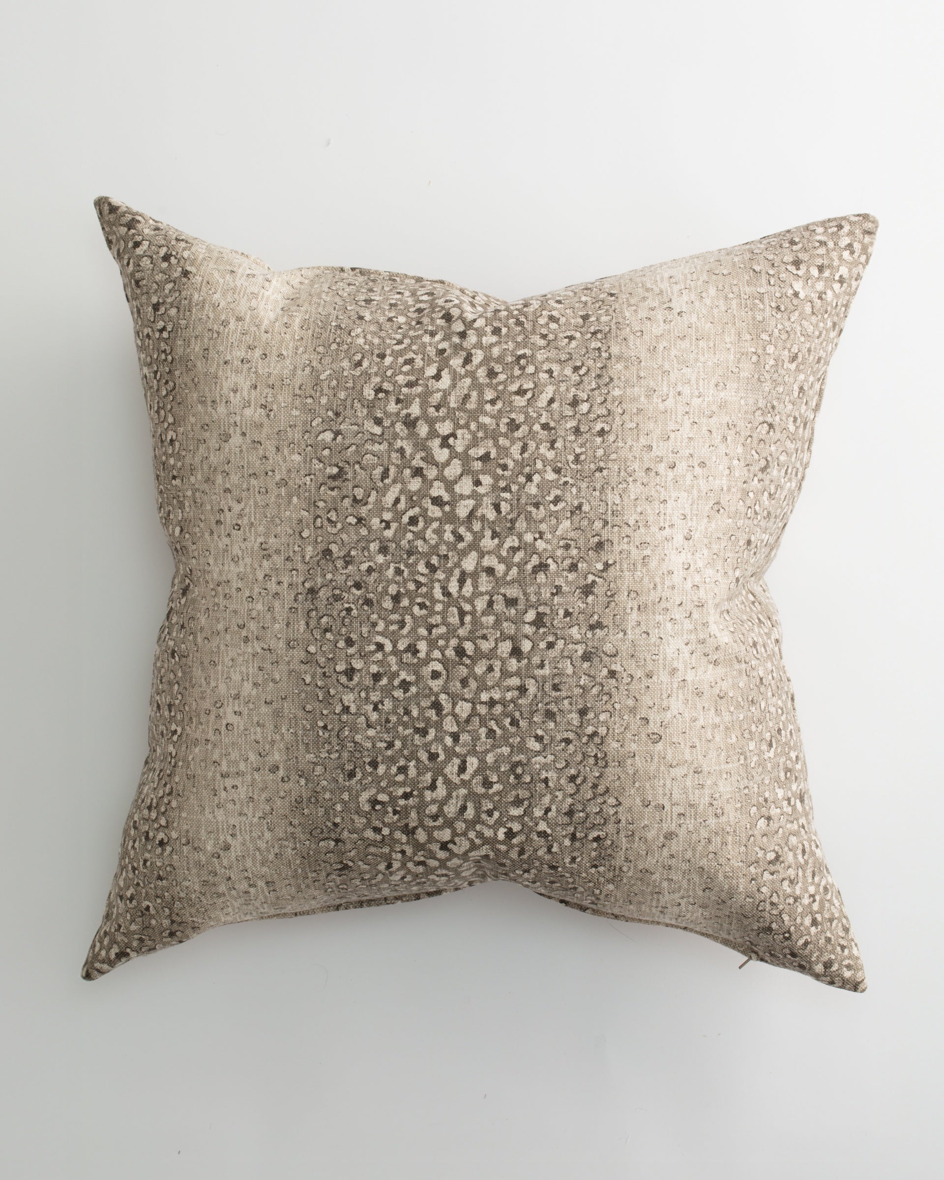The BALOO 26x26 Pillow by Pindler features textured woven fabric in beige and taupe with a subtle speckled center. This luxurious square decorative pillow is perfect for layering on your bed or sofa. Background is white.