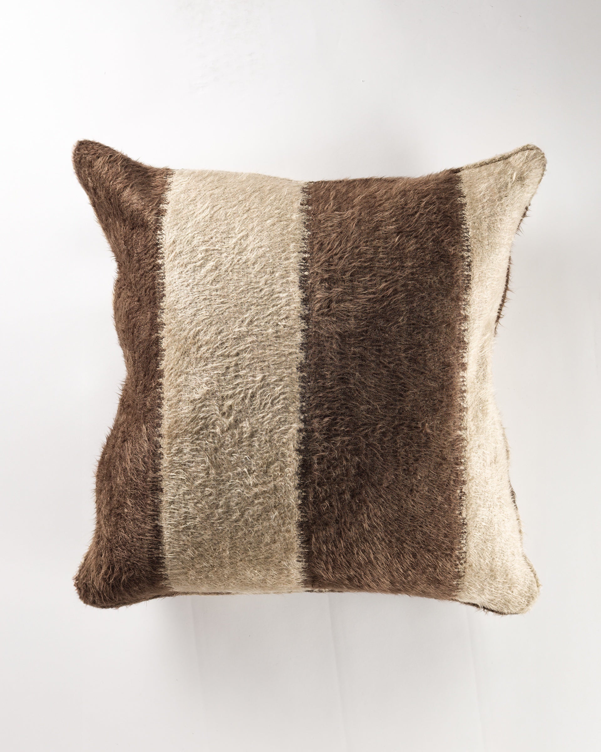 The Gabby Fleecy Stripe Chocolate Gr-10 Pillow 26x26 features a furry texture with wide beige and brown vertical stripes. Includes pillow insert. Shown against a plain white background.