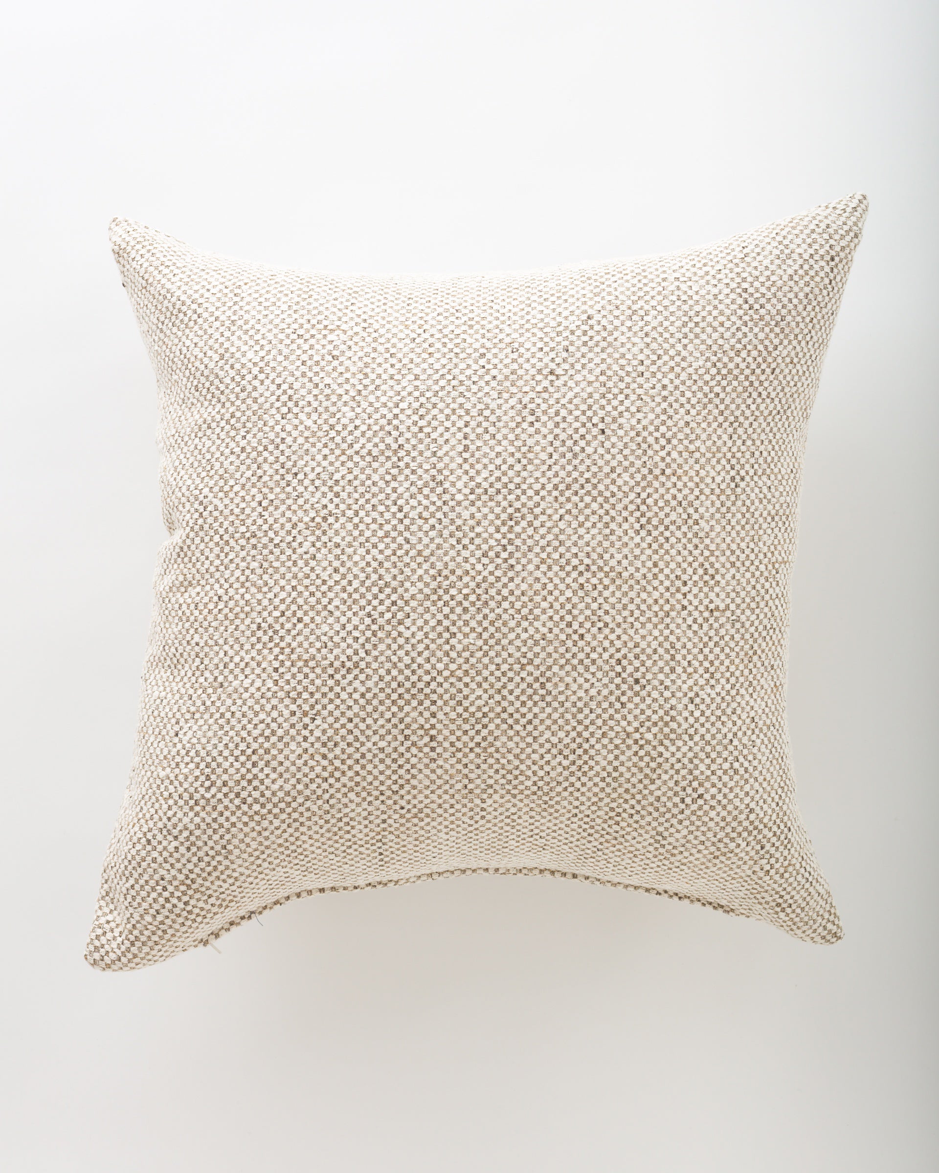 A Nash 26x26 euro pillow by Pindler, in textured beige with a subtle woven pattern and gently pointed corners, is displayed on a white surface from above.
