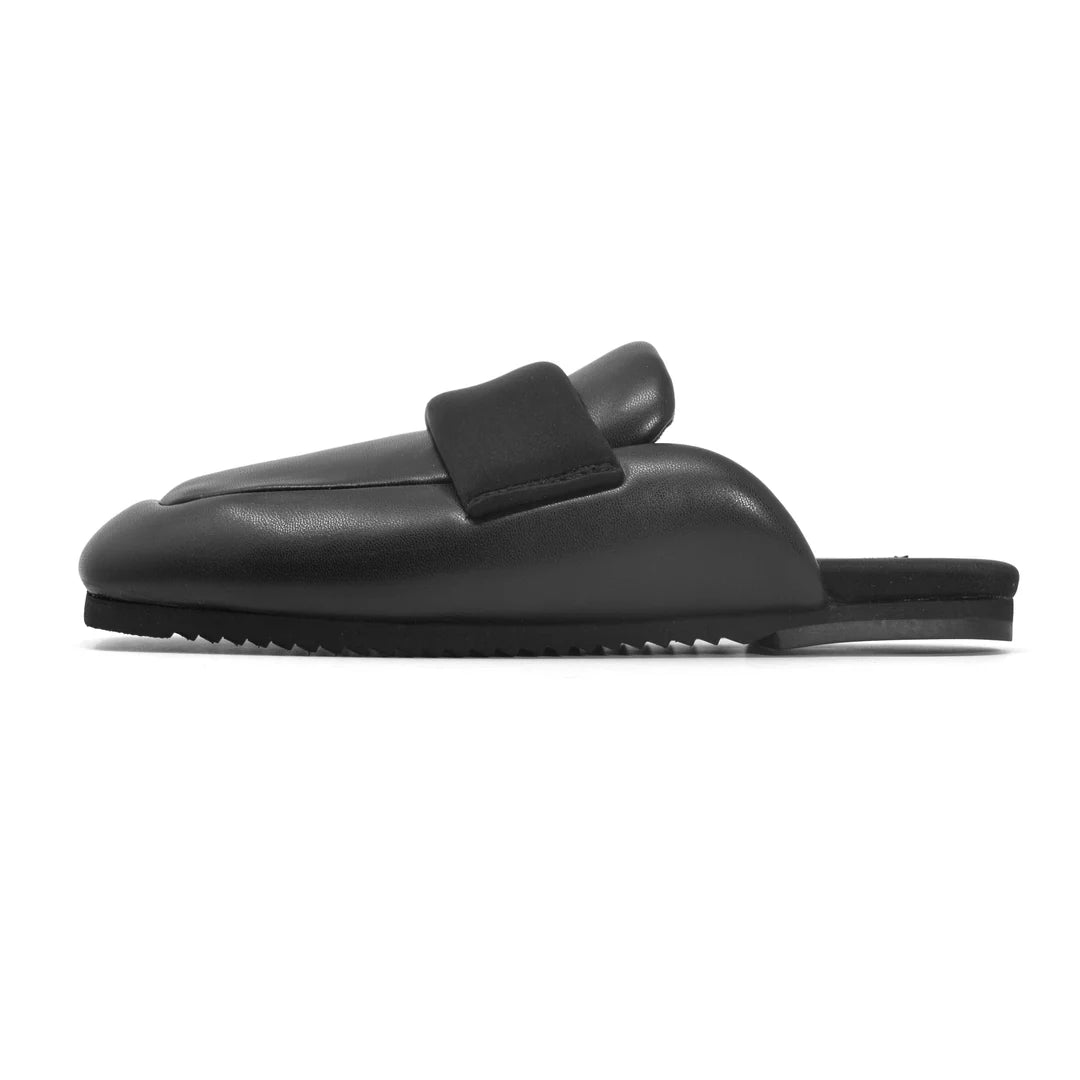 The Roam Puffy Loafer is a black, backless slip-on mule with a thick cushioned upper, memory foam insoles, rounded toe, and flat sole, shown in side profile on a plain white background.