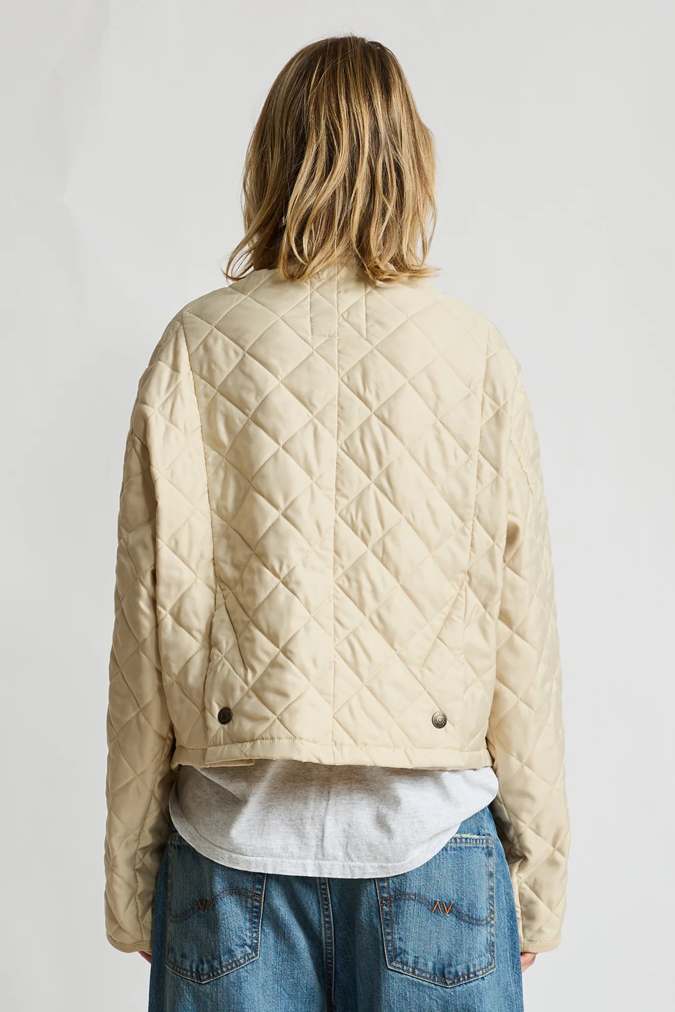 Denimist Faulkner quilted jacket in blue, shown from behind with jeans against a plain white background.