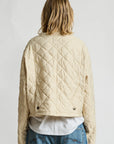 Denimist Faulkner quilted jacket in blue, shown from behind with jeans against a plain white background.