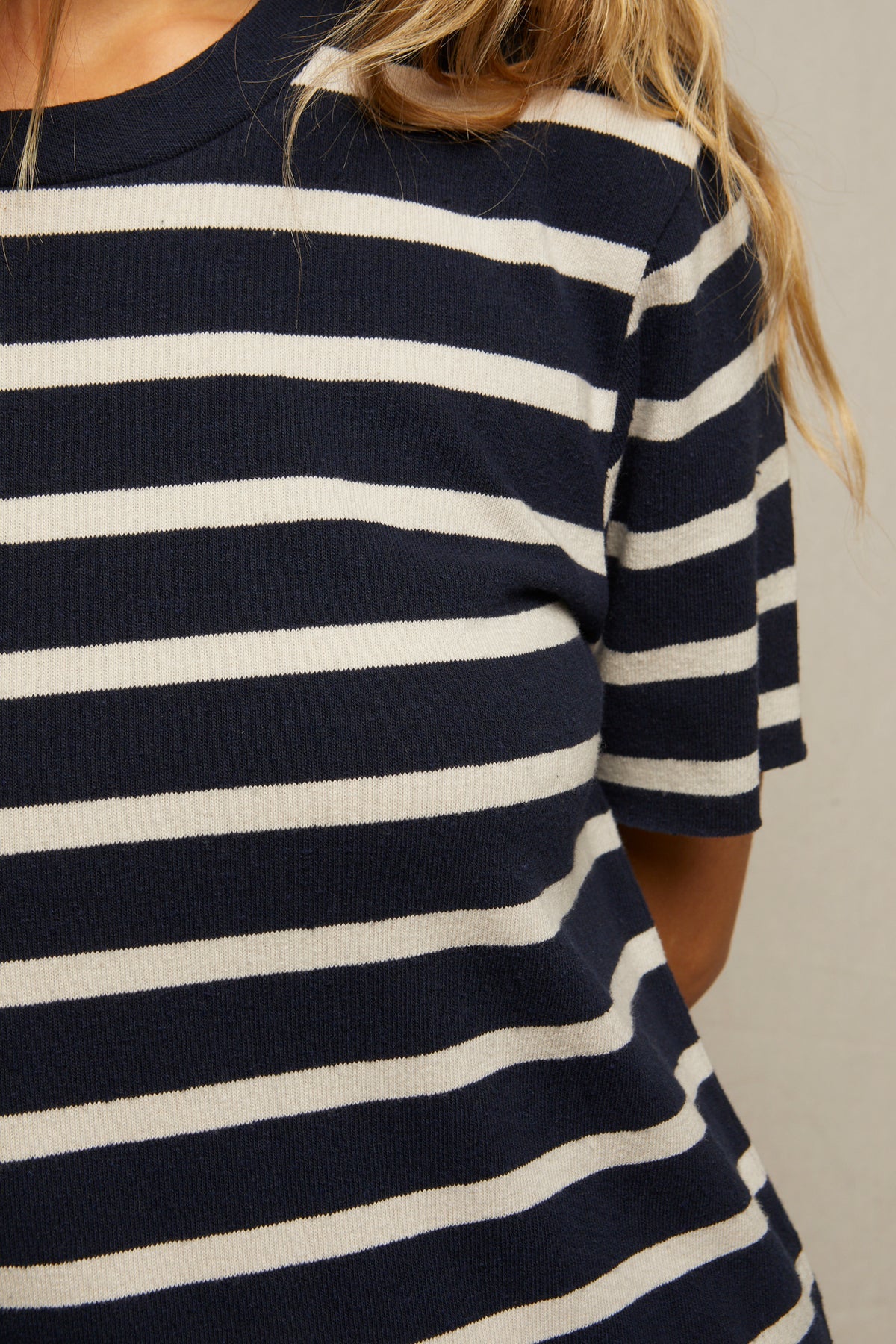 Close-up of a striped beauty wearing the Perfectwhitetee Rhett SS Tee Dress in navy blue and white. The face is not visible, and long, light brown hair falls over the shoulder.