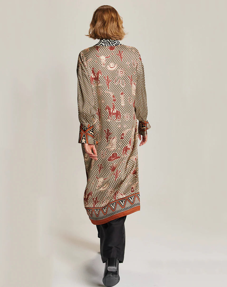 A person with short, light brown hair is seen from behind wearing the Me369 Athena Collar Button Up over black pants and dark shoes, standing against a plain background.