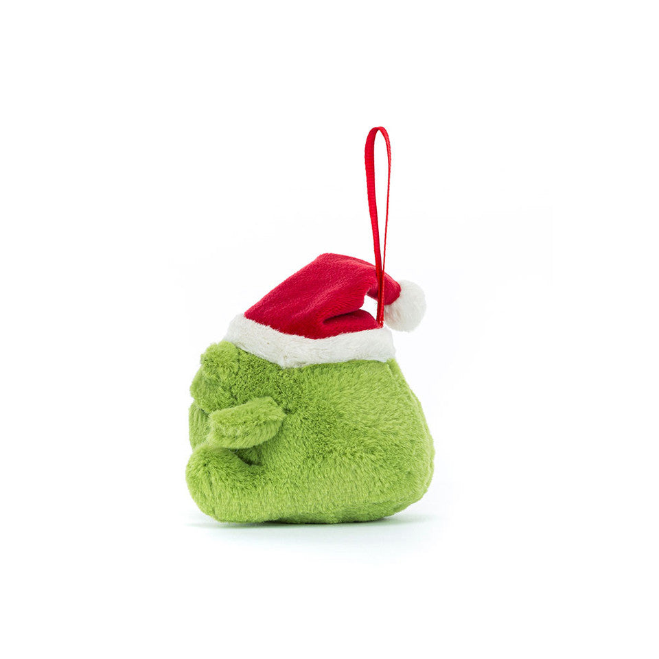 The Ricky Rain Frog Decoration by Jelly Cat Inc. is a small, plush green frog ornament with a grumpy face, wearing a red and white Santa hat and a red hanging loop. It is shown against a plain white background.