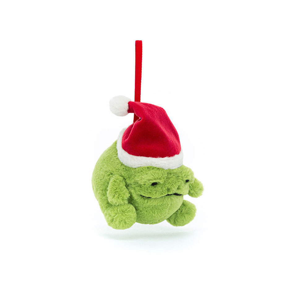 A Ricky Rain Frog Decoration by Jelly Cat Inc. hangs by a red loop against a white background, featuring a plush green grumpy frog wearing a red and white Santa hat.