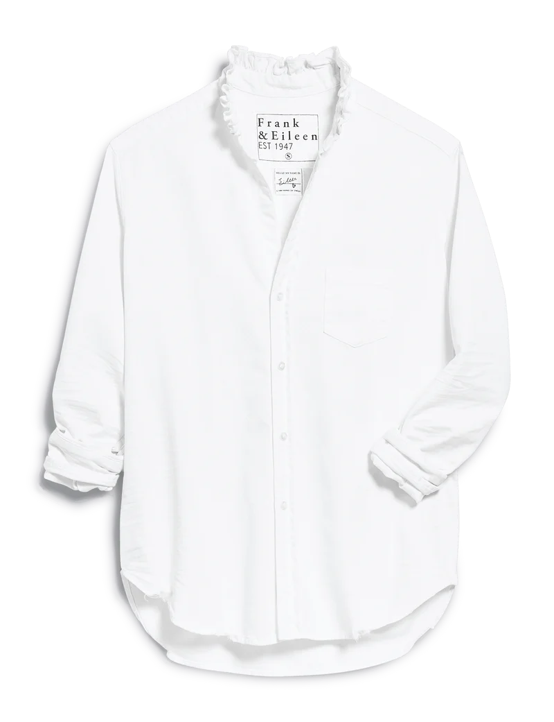 The Frank & Eileen Ruffle/Eileen Button Up is a white shirt with a flattering fit, ruffled collar, single chest pocket, and partially rolled-up sleeves.