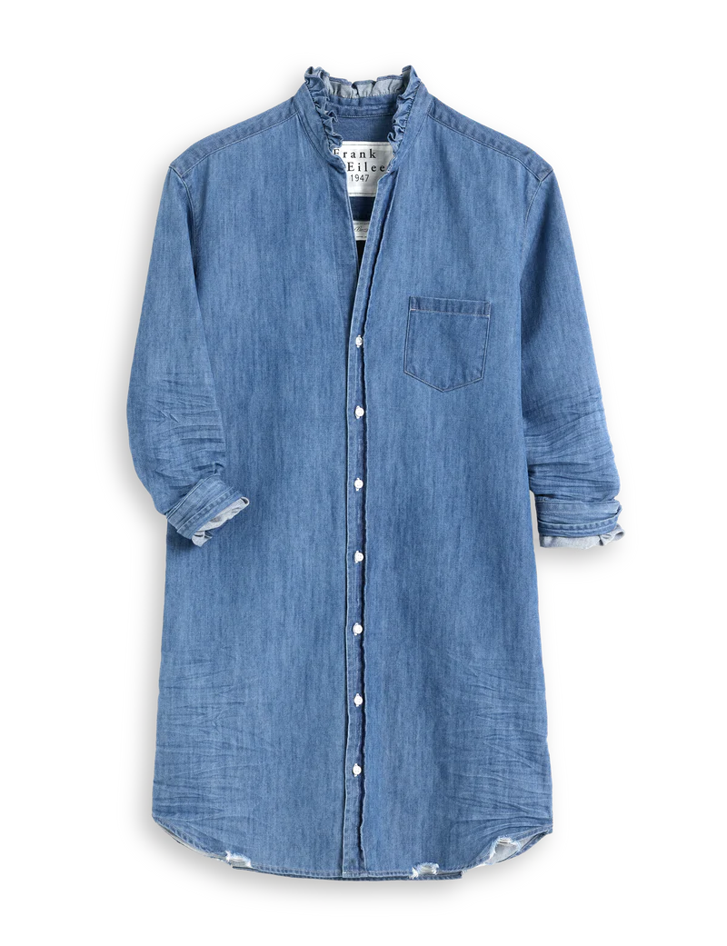 The Mary Classic Shirtdress-Ruffle by Frank & Eileen is a long-sleeved, knee-length denim dress with a stand collar, front button closure, chest pocket, and subtly frayed cuffs and hem.