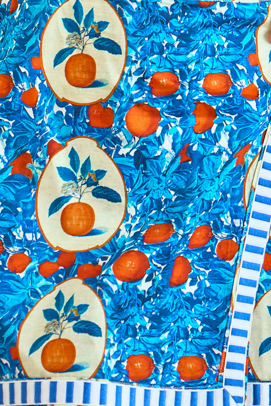 This vibrant stretch sateen fabric showcases an "Orange Grove" print with oranges and blue leaves, some encircled by beige ovals, and a striking white-blue striped border. It's perfect for crafting the stylish Powell Skirt by Hunter Bell NYC.