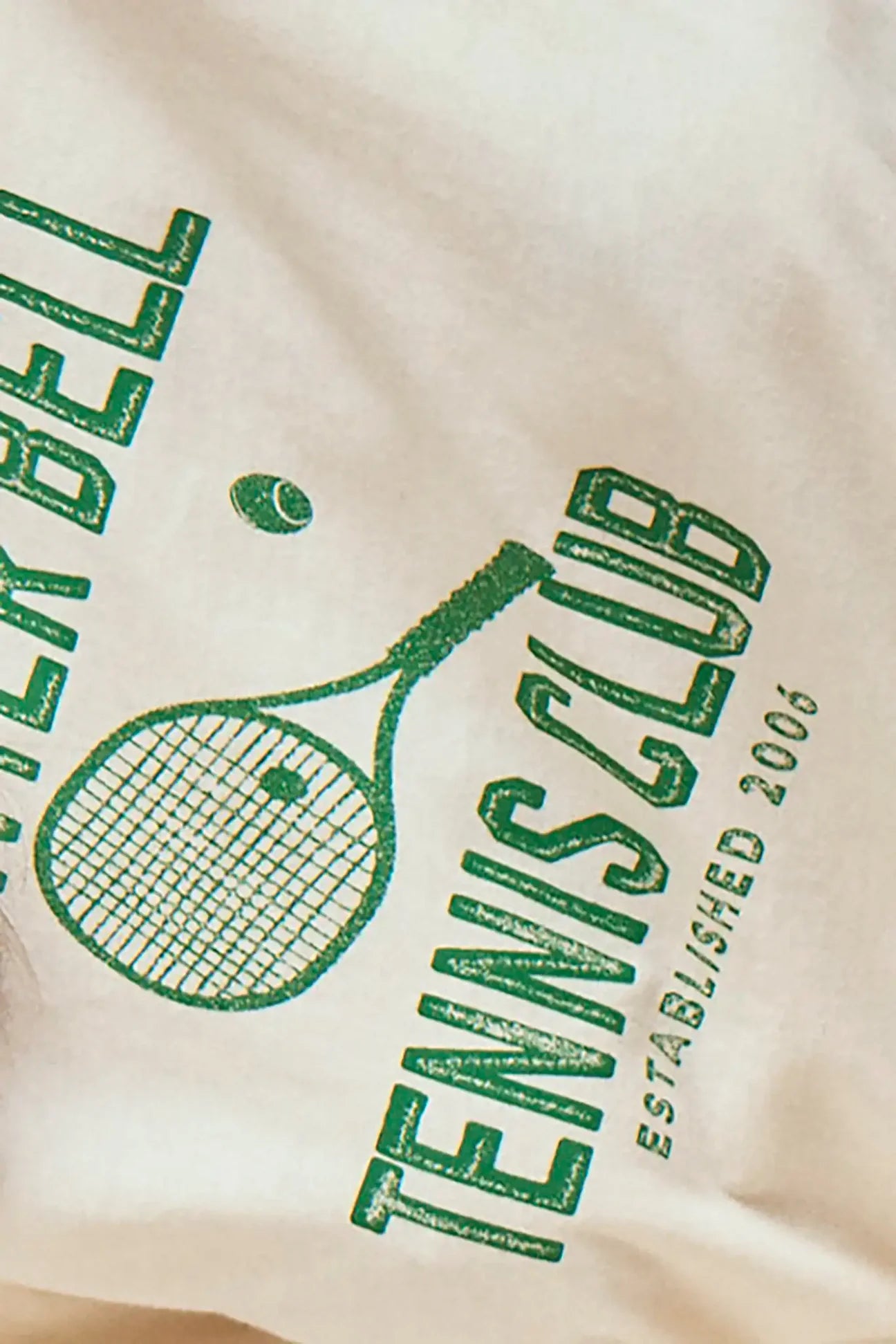 The Tennis Club Tee by Hunter Bell NYC is a white crew neck featuring a green HB Graphic Design with a tennis racket, ball, and bold "TENNIS CLUB ESTABLISHED 2006" lettering.