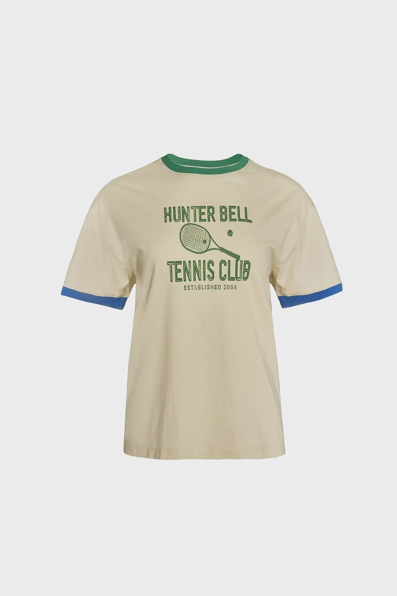 The Hunter Bell NYC Tennis Club Tee is a beige ringer t-shirt in soft jersey knit, featuring a green collar, blue sleeve cuffs, and an HB tennis racket graphic with "HUNTER BELL TENNIS CLUB ESTABLISHED 2006" text.