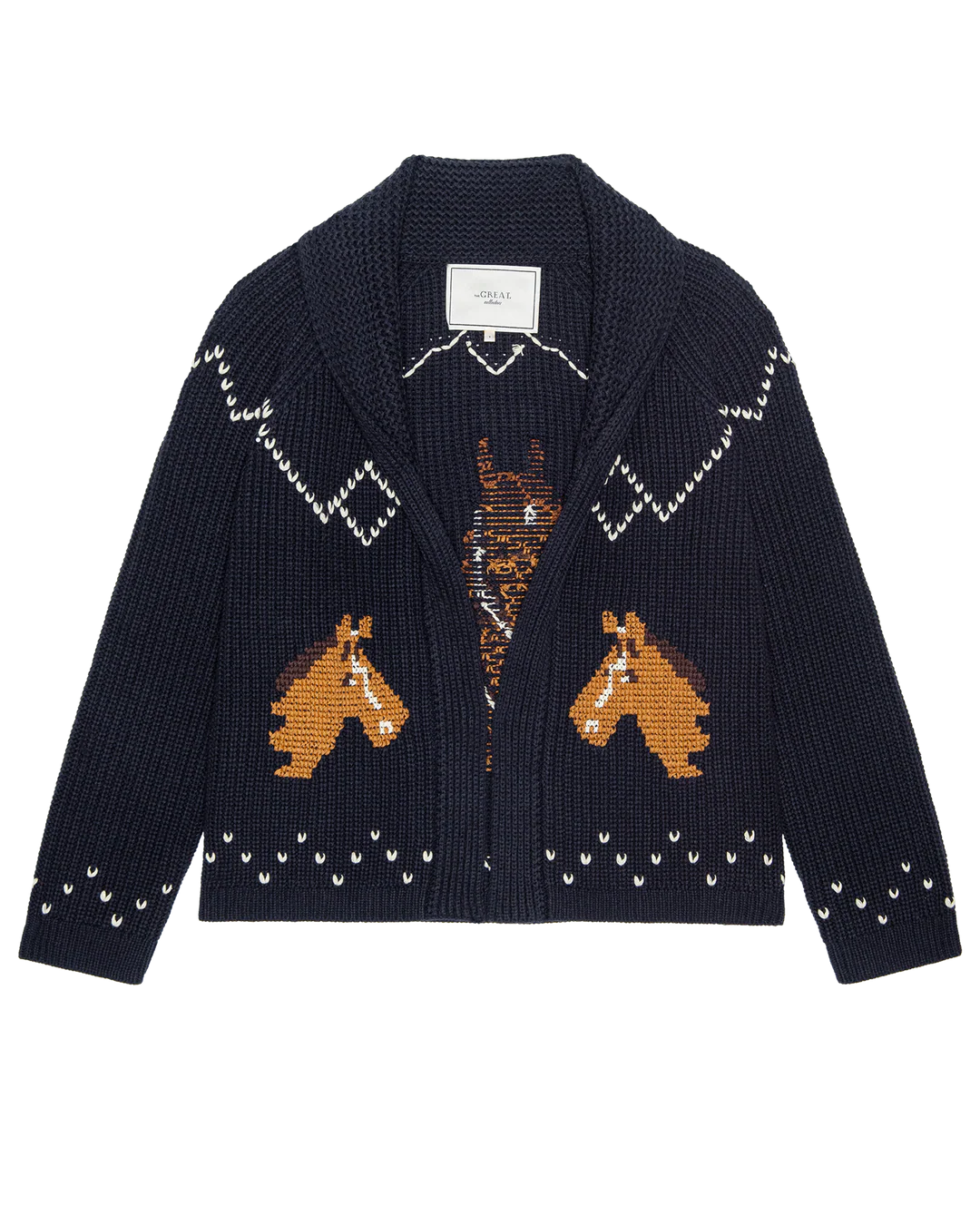 The Great Inc. Horse Lodge Cardigan in navy features white patterns, two hand-embroidered horses on the front, a shawl collar, visible neckline label, and a western-inspired design.