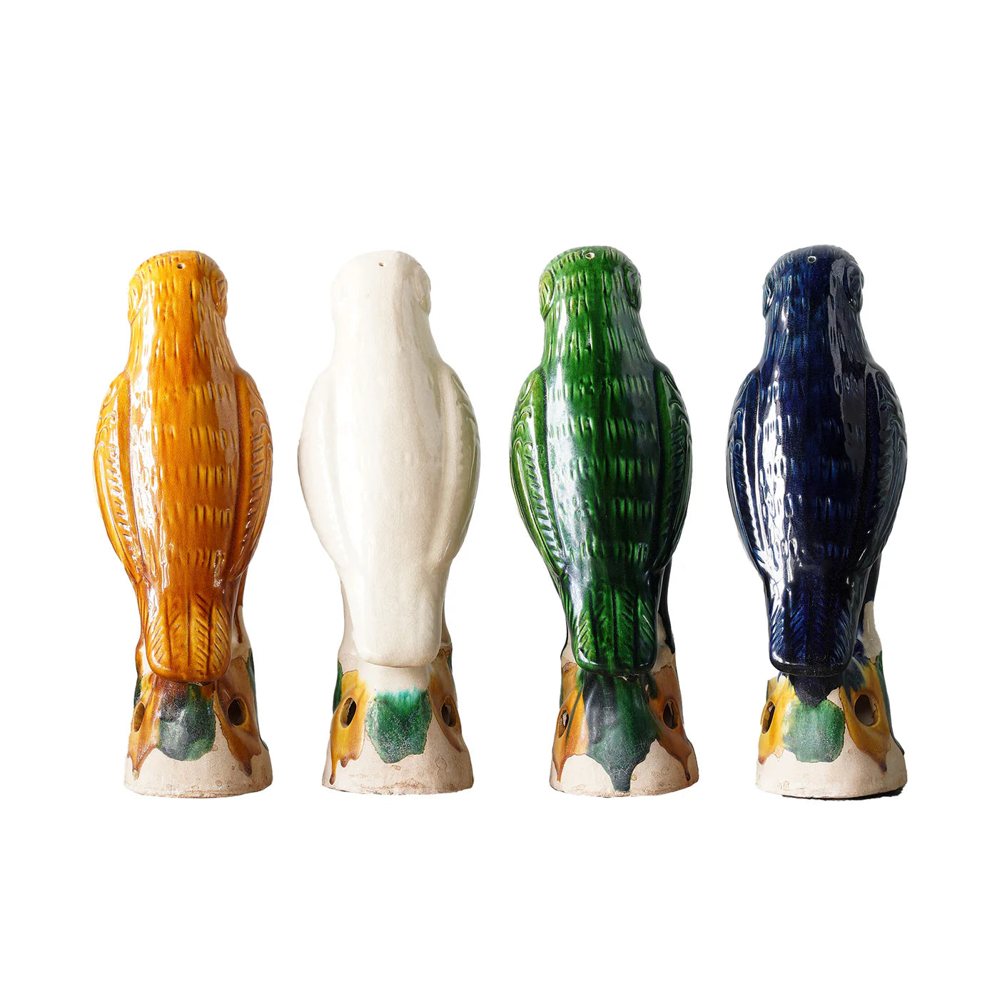 Four "Parrot Small" ceramic figurines by Blue Ocean Traders, inspired by Jingdezhen hand-painted porcelain, are painted in yellow, white, green, and blue and arranged in a row facing away on a white background.