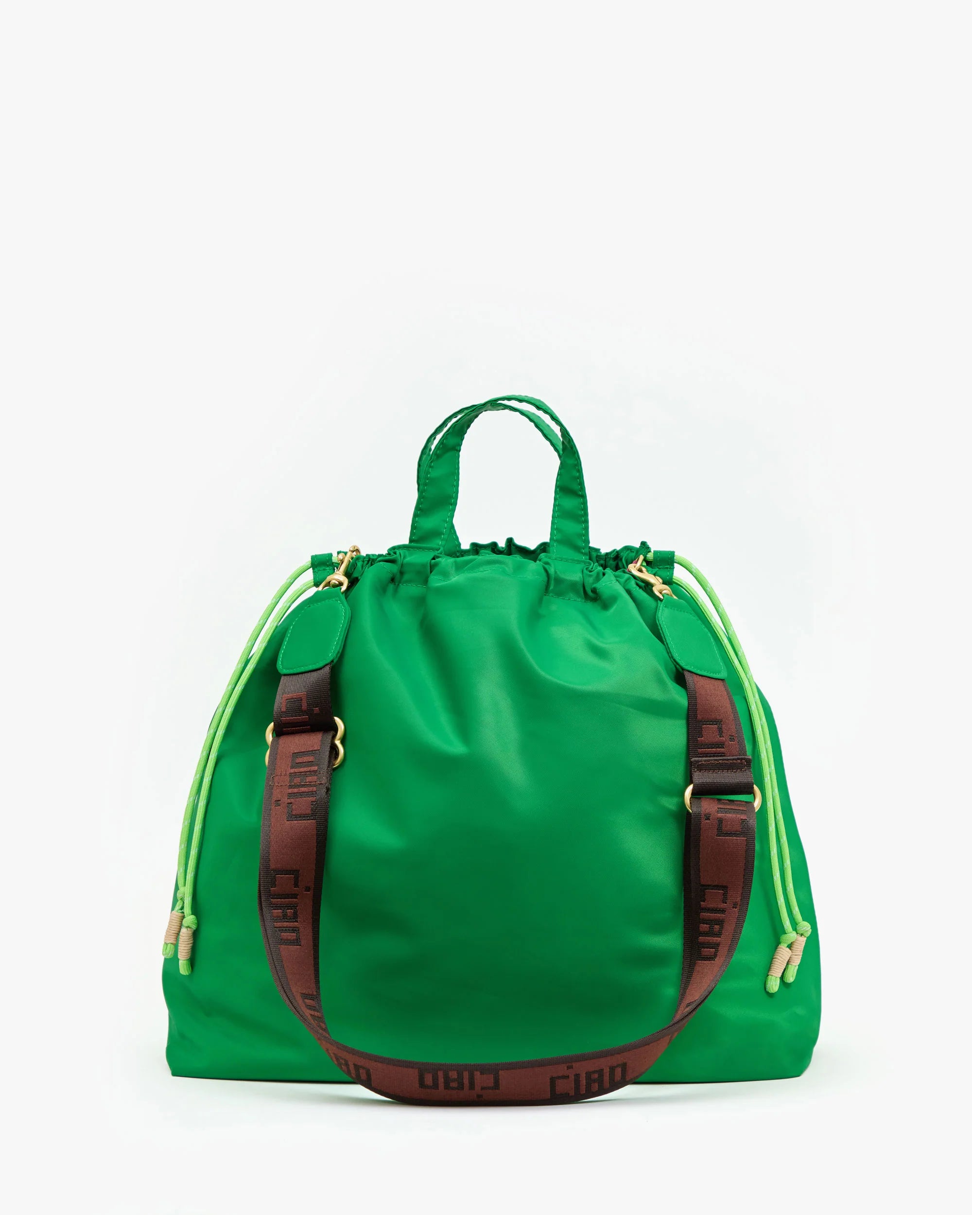 The Sac Tout by Clare Vivier is a vibrant green tote with short handles, neon yellow drawstring sides, a detachable brown crossbody strap, and bold "CIAO" lettering.