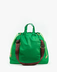 The Sac Tout by Clare Vivier is a vibrant green tote with short handles, neon yellow drawstring sides, a detachable brown crossbody strap, and bold "CIAO" lettering.