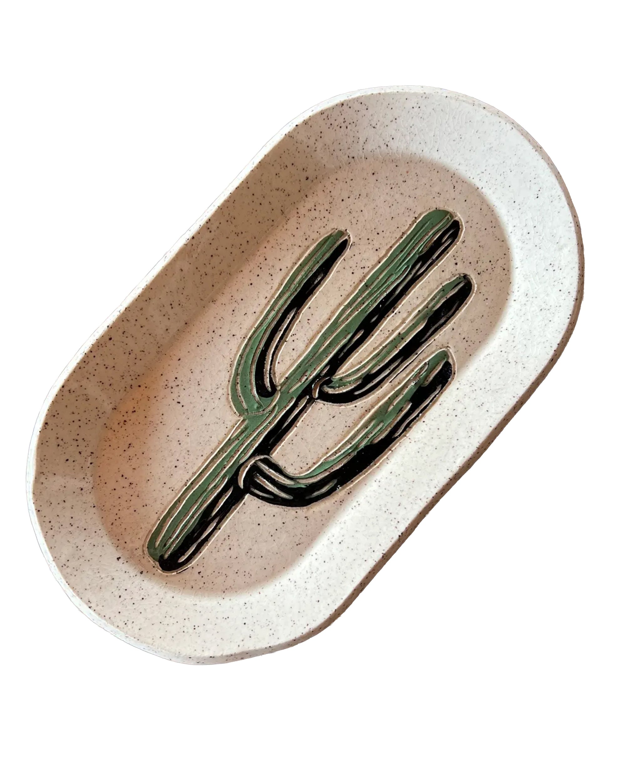 The Saguaro Oval Trinket Dish by Faire is a handmade, speckled ceramic dish featuring a painted green cactus design—ideal as a trinket holder or for adding desert-inspired decor. Shown here against a white background.