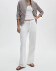 A person wearing Rag & Bone ftwt saige full straight jeans, a brown and white striped blazer, a white tank top, and brown sandals stands against a plain white background.