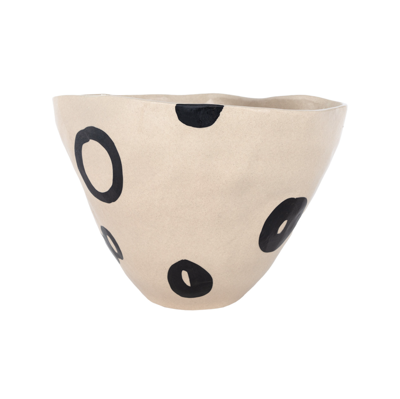 The Clyde Bowl by The Import Collection is a beige porcelain piece with an uneven rim, featuring bold black circles and ovals across its surface—a uniquely detailed design.