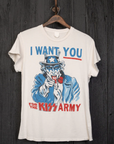 The Kiss Wants You Crew Tee by Made Worn, a vintage unisex white cotton t-shirt, is showcased on a wooden wall. Handmade in Los Angeles, it depicts Uncle Sam with face paint pointing forward and is adorned with the bold message "I WANT YOU FOR THE KISS ARMY" in striking blue and red letters.