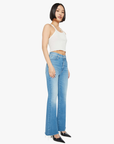 A person with a bob haircut is wearing a white cropped tank top and the Lil HW Weekender Fray jeans by Mother, crafted from soft stretch denim. They stand slightly to the side, hands by their sides, against a plain white backdrop.