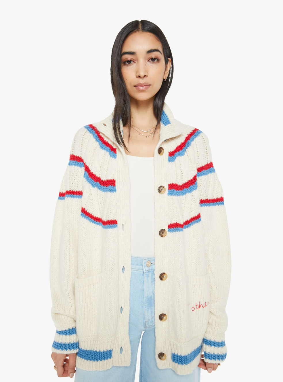 A woman with long dark hair models The Mock Neck Button Cardigan by Mother, featuring a slouchy fit with blue and red stripes over a white top. This alpaca cotton blend cardigan has large buttons and two front pockets, set against a plain white background.