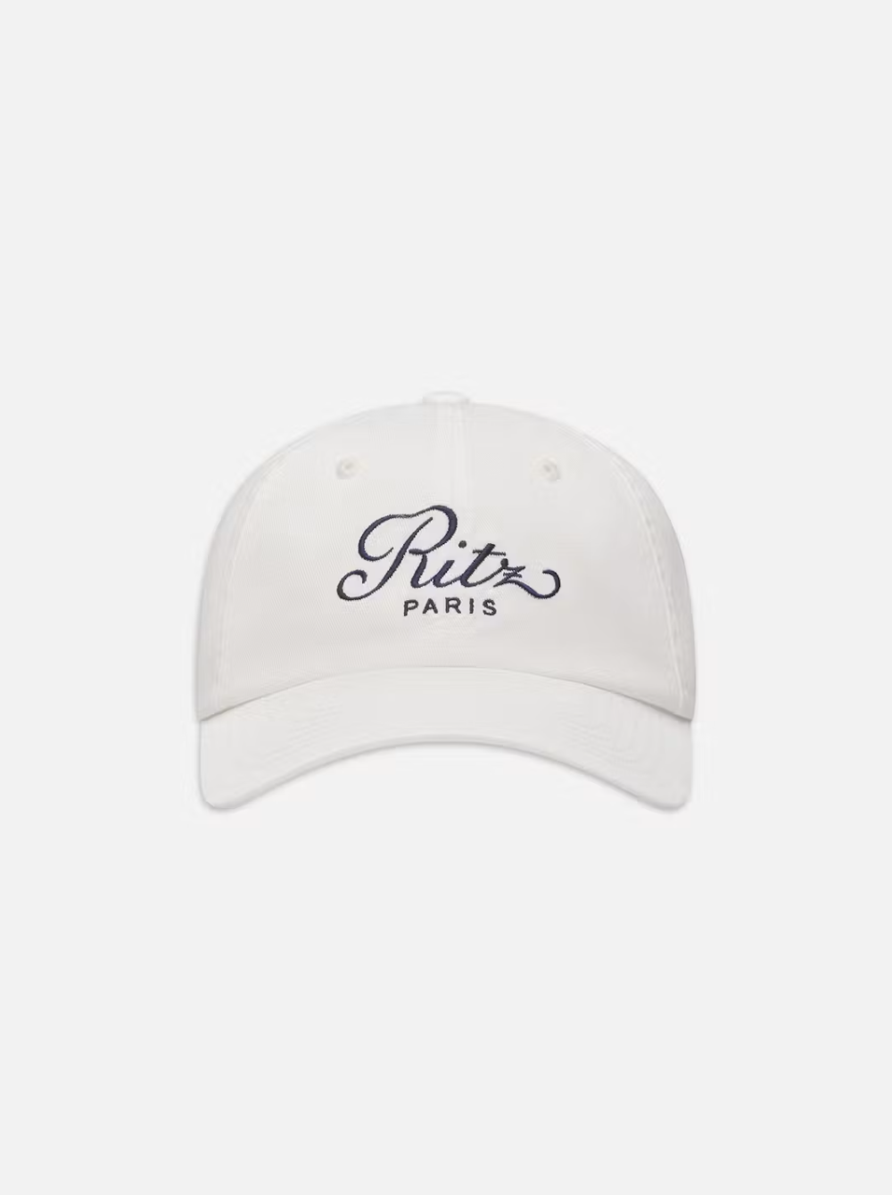 The FRAME Ritz Cotton Trucker is a 100% cotton cap with the Ritz Paris logo embroidered in black script on a plain white background.