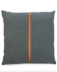 The Atlas Pillow by Libeco Home features a square gray design with a vertical brown stripe and two thin white lines. Its soft, slightly wrinkled texture and plush insert create an elegant contrast against the plain white background of the sofa.