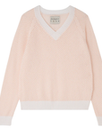 The Holey Contrast Vee from Jumper 1 2 3 4/CR2 is a light pink cashmere jumper featuring an airy, textured knit with white trim on the V-neckline, cuffs, and hem. It offers an oversized fit.