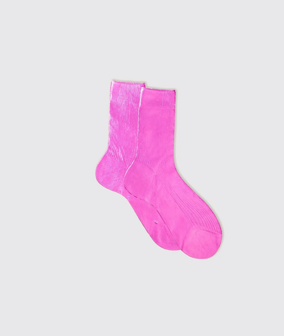 The image shows a pair of Flash Socks by Maria La Rosa, crafted from bright pink silk in Italy. They are displayed on a light gray background with one sock slightly overlapping the other, highlighting their vibrant color and simple design.