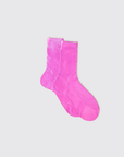 The image shows a pair of Flash Socks by Maria La Rosa, crafted from bright pink silk in Italy. They are displayed on a light gray background with one sock slightly overlapping the other, highlighting their vibrant color and simple design.