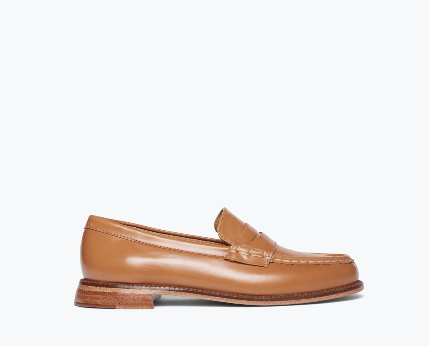 The ELBA Loafer by Freda Salvador is spotlighted against a simple white backdrop. This tan Italian leather shoe is handcrafted with stitch detailing around the toe, a small heel, and a smooth polished finish.